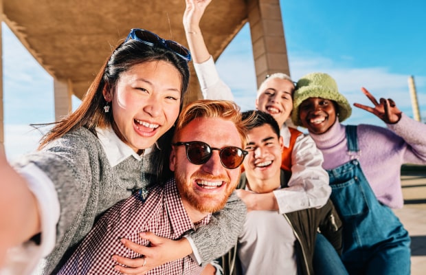 multiracial group of young friends having fun make