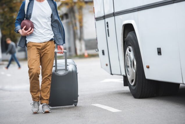 partial view of man with rugby ball carrying bag